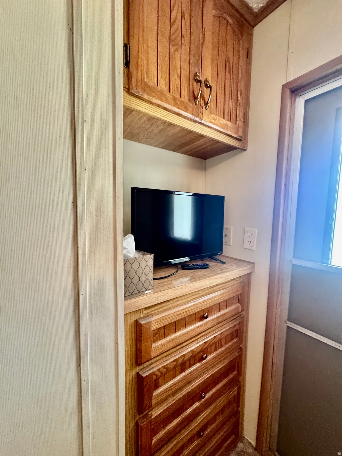 Built-in cabinetry with wood-finish doors and drawers, featuring decorative pulls and a light-toned countertop
