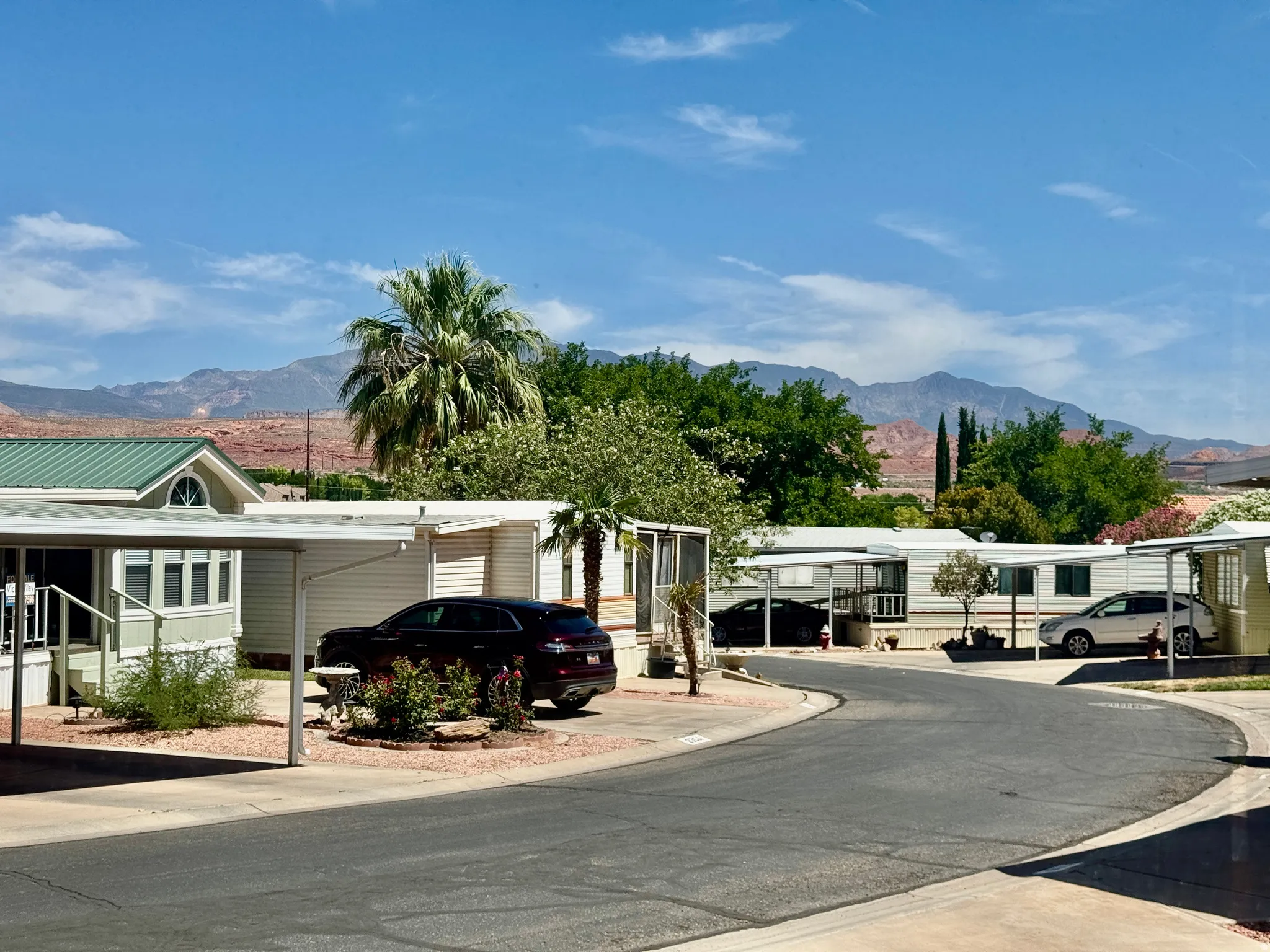 Residential street with homes featuring covered parking and mountain backdrop
