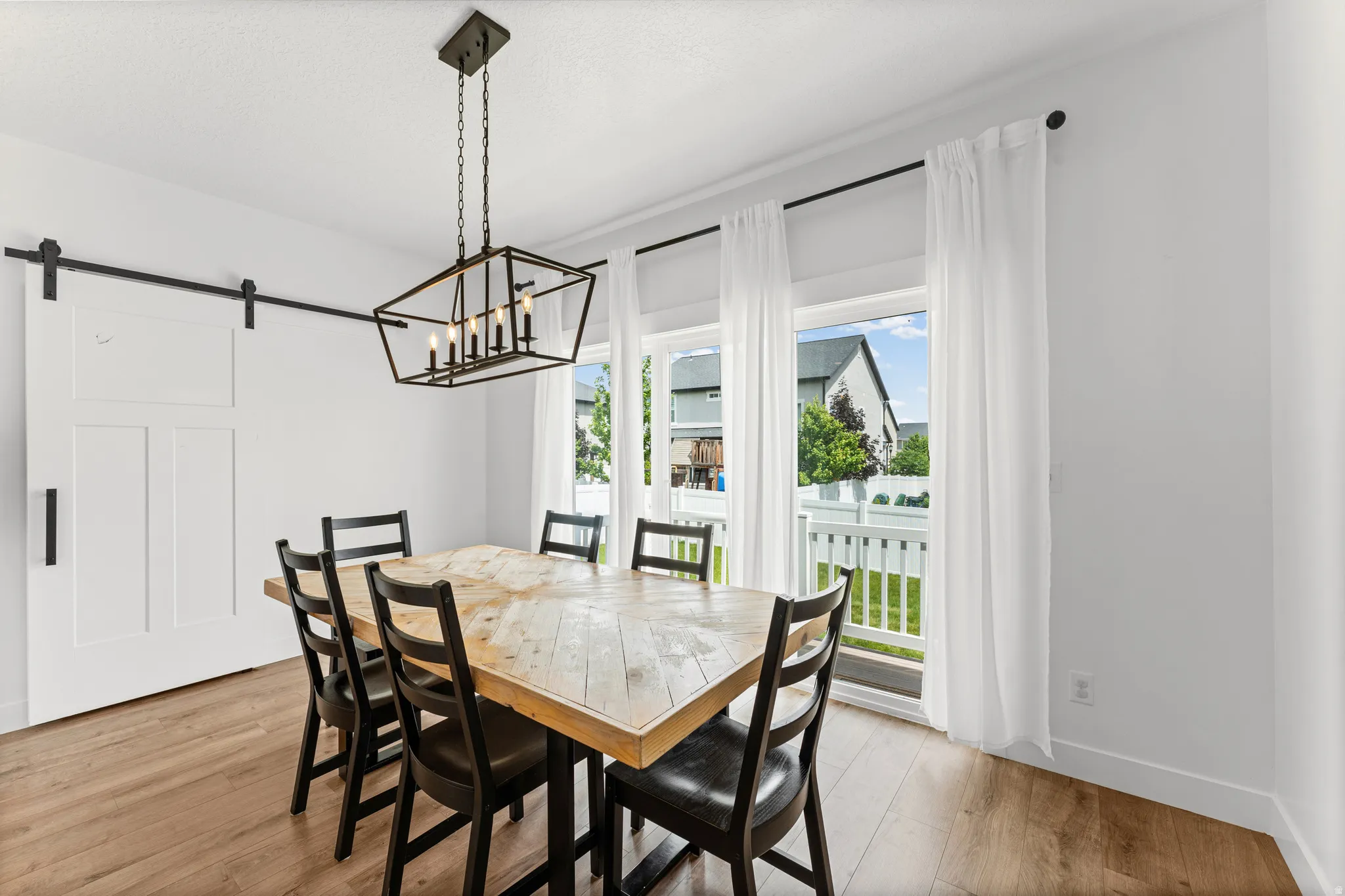 Dining area featuring wood-finish flooring and a white barn door