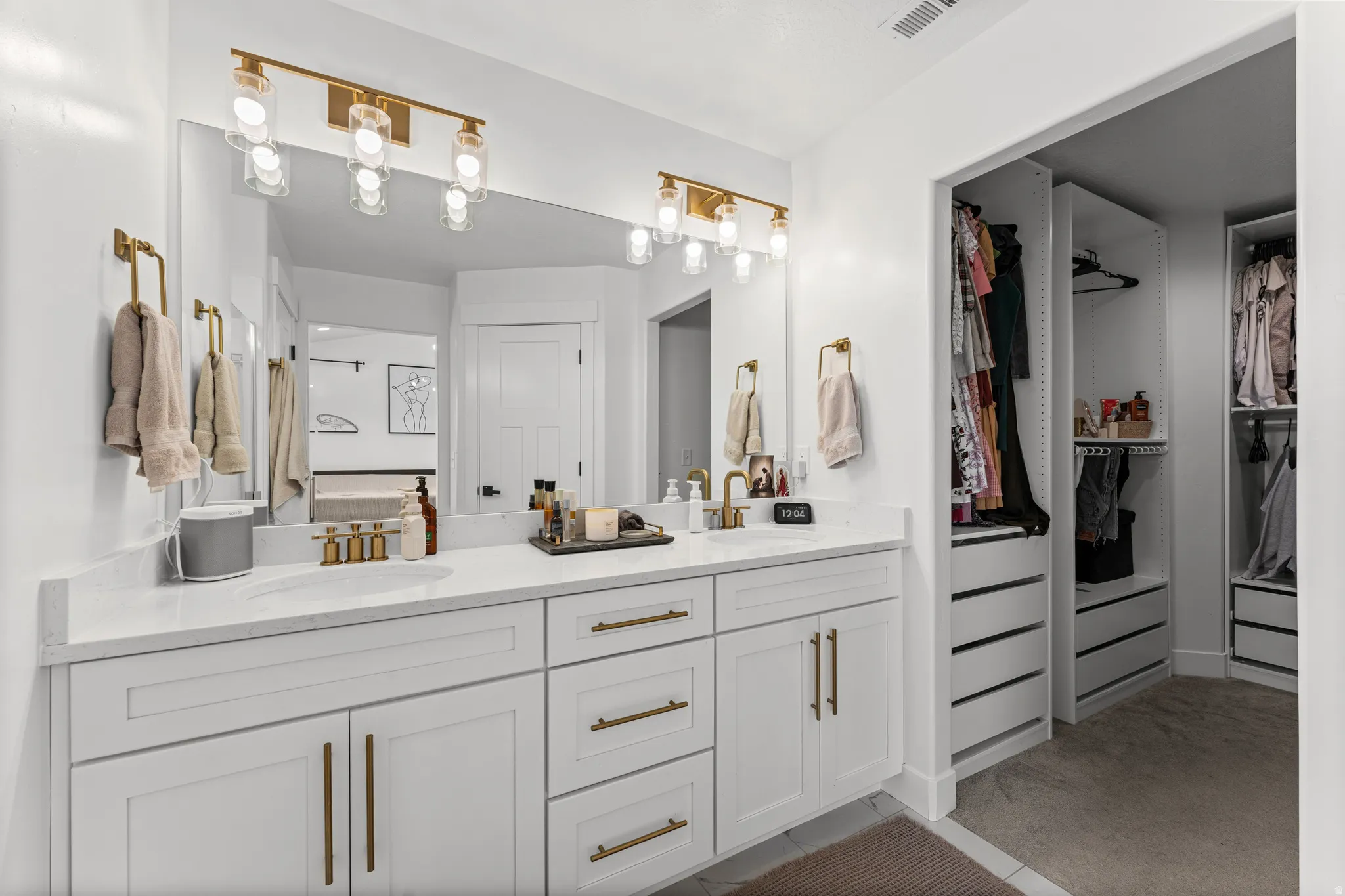 Double vanity with quartz countertop, dual undermount sinks, and gold-finish fixtures