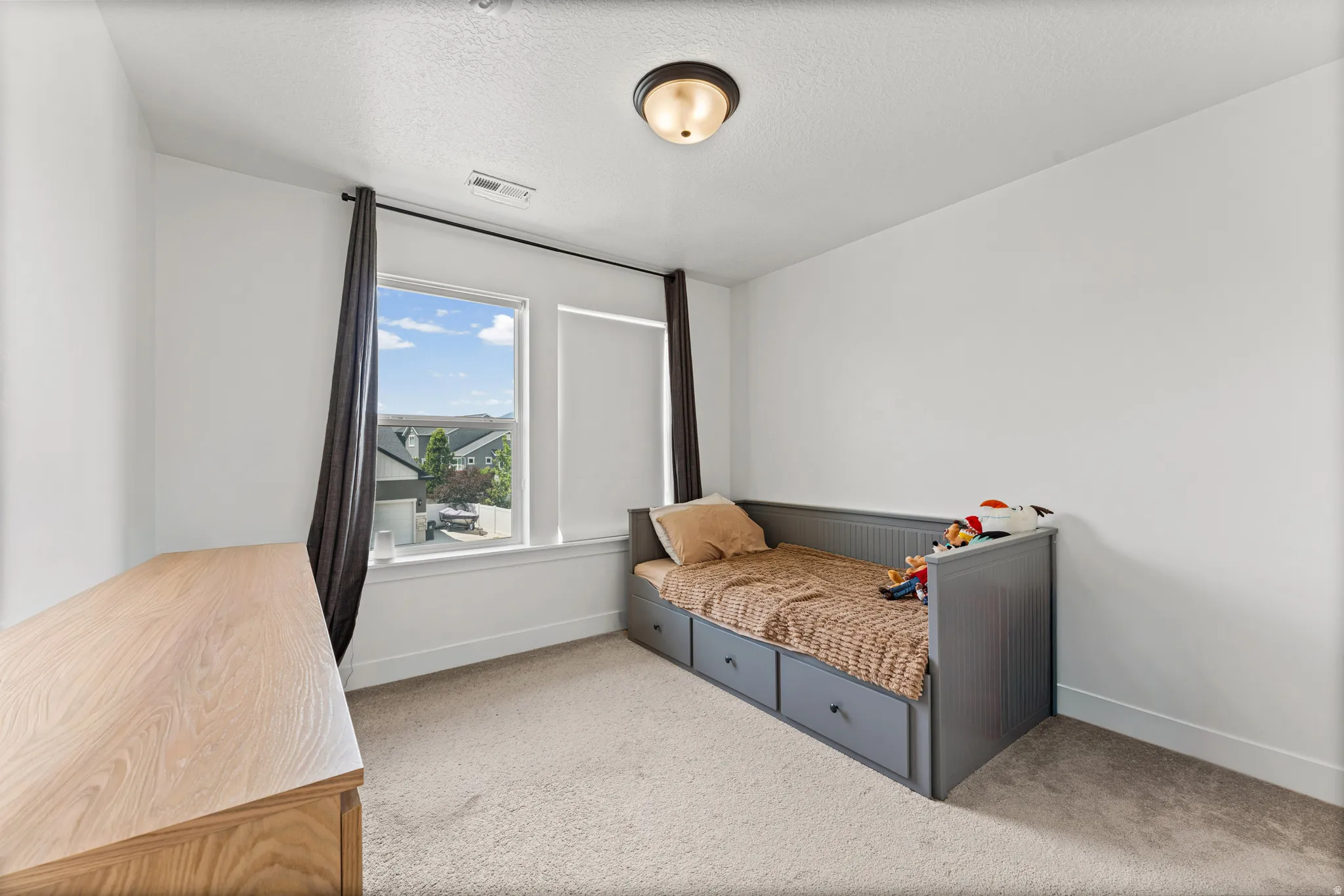 Bright room featuring two windows with white trim, neutral carpet, and white walls