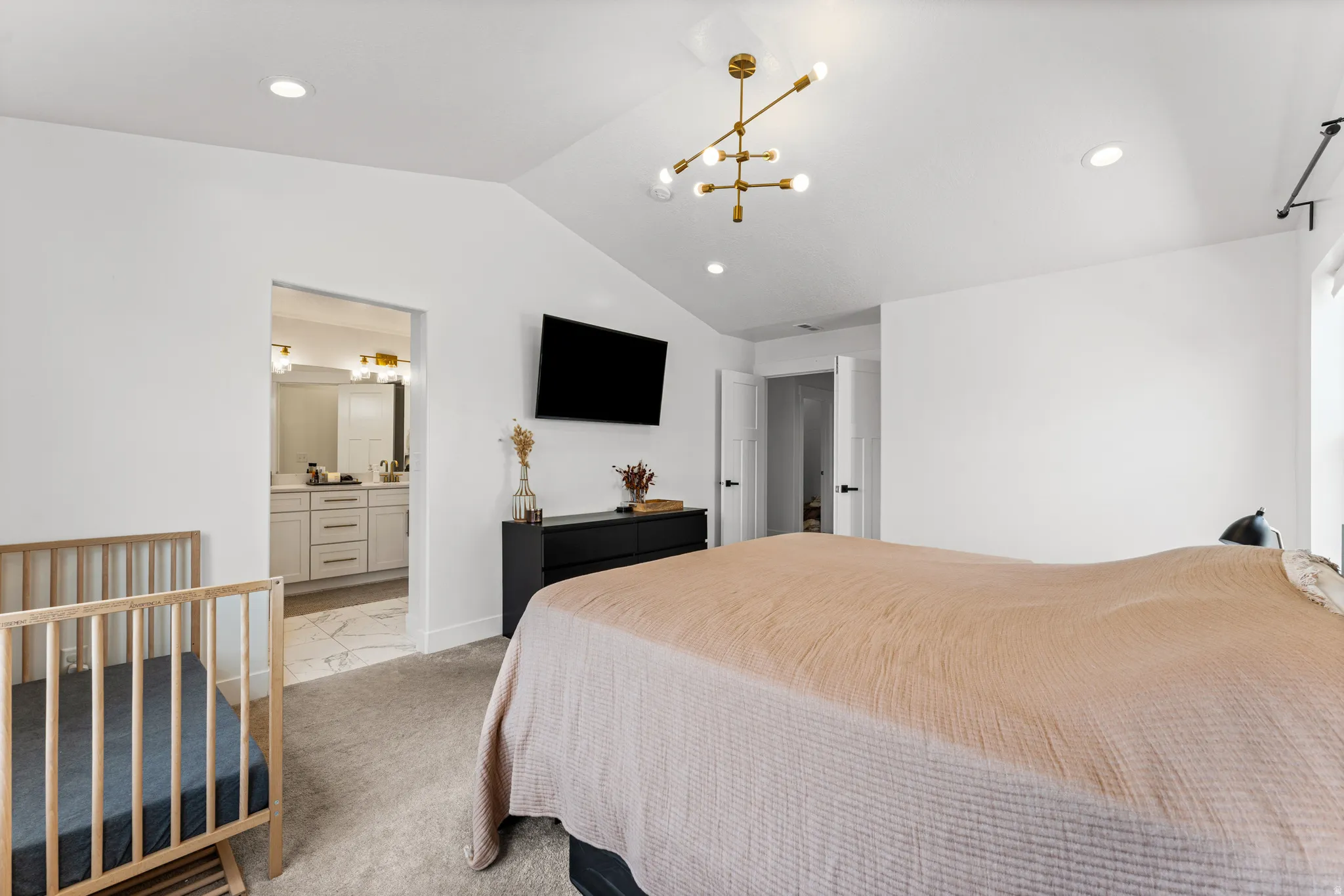 Vaulted ceiling bedroom with recessed lighting and a brass linear chandelier