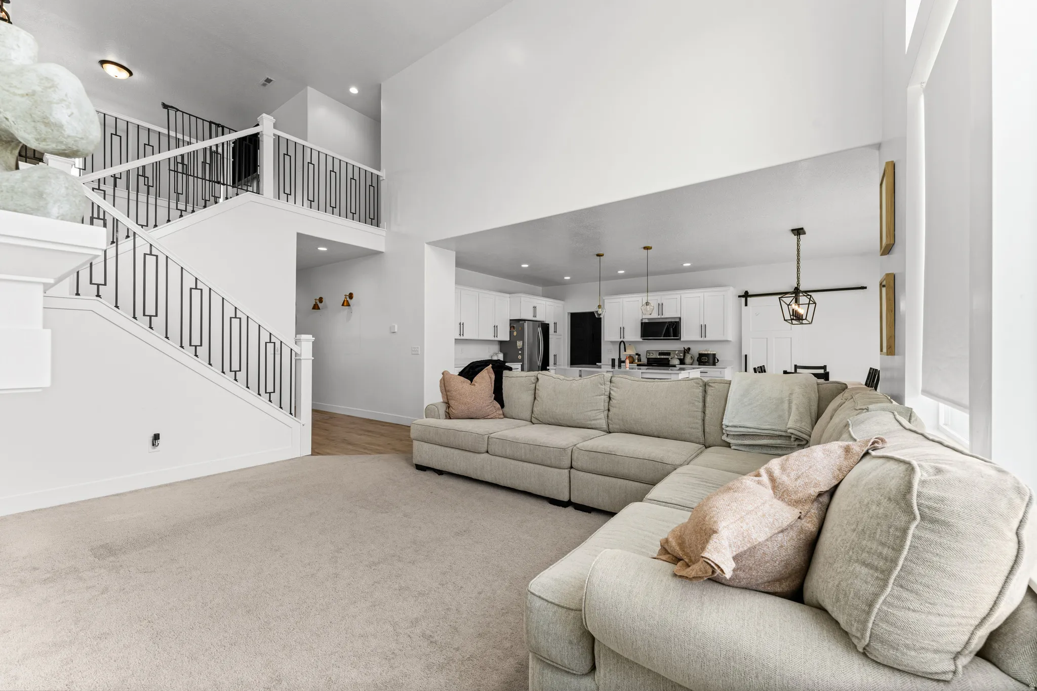 Open-concept interior featuring a two-story ceiling and a carpeted living area