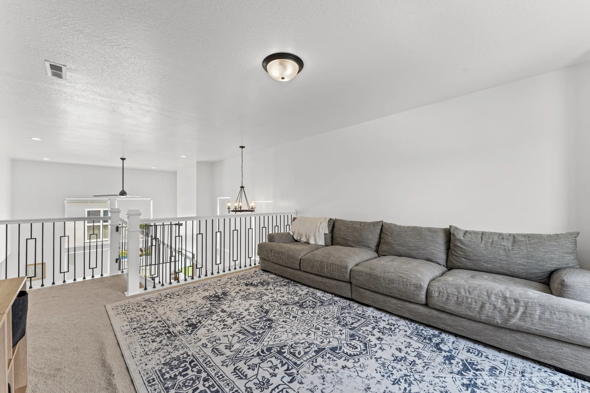 Upper-level loft space featuring white walls and a carpeted floor