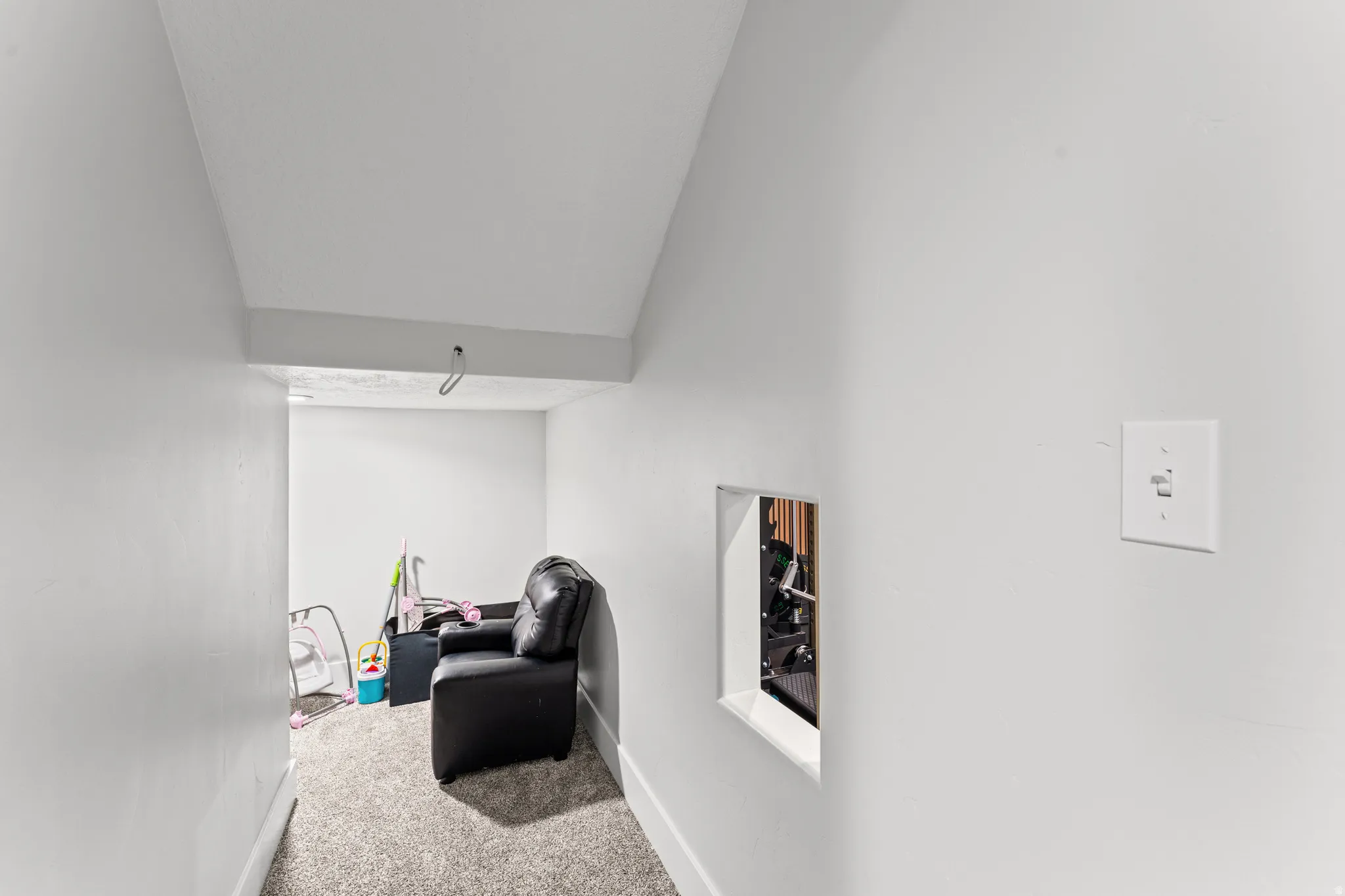 Carpeted hallway with white painted walls and ceiling