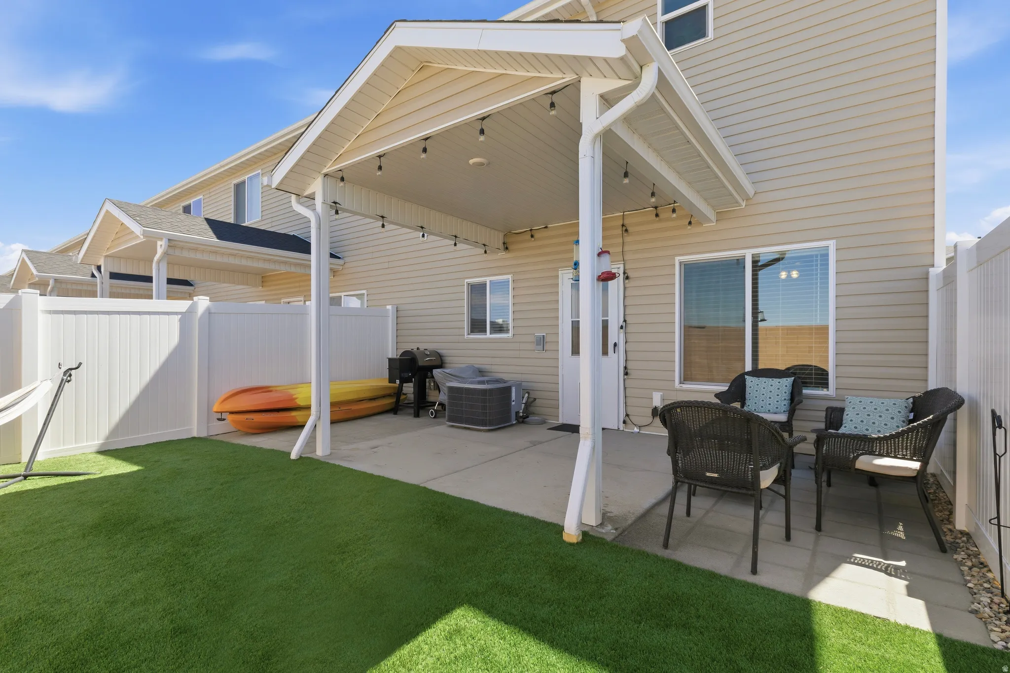 Enclosed patio area featuring a covered concrete pad, string lighting, and direct entry