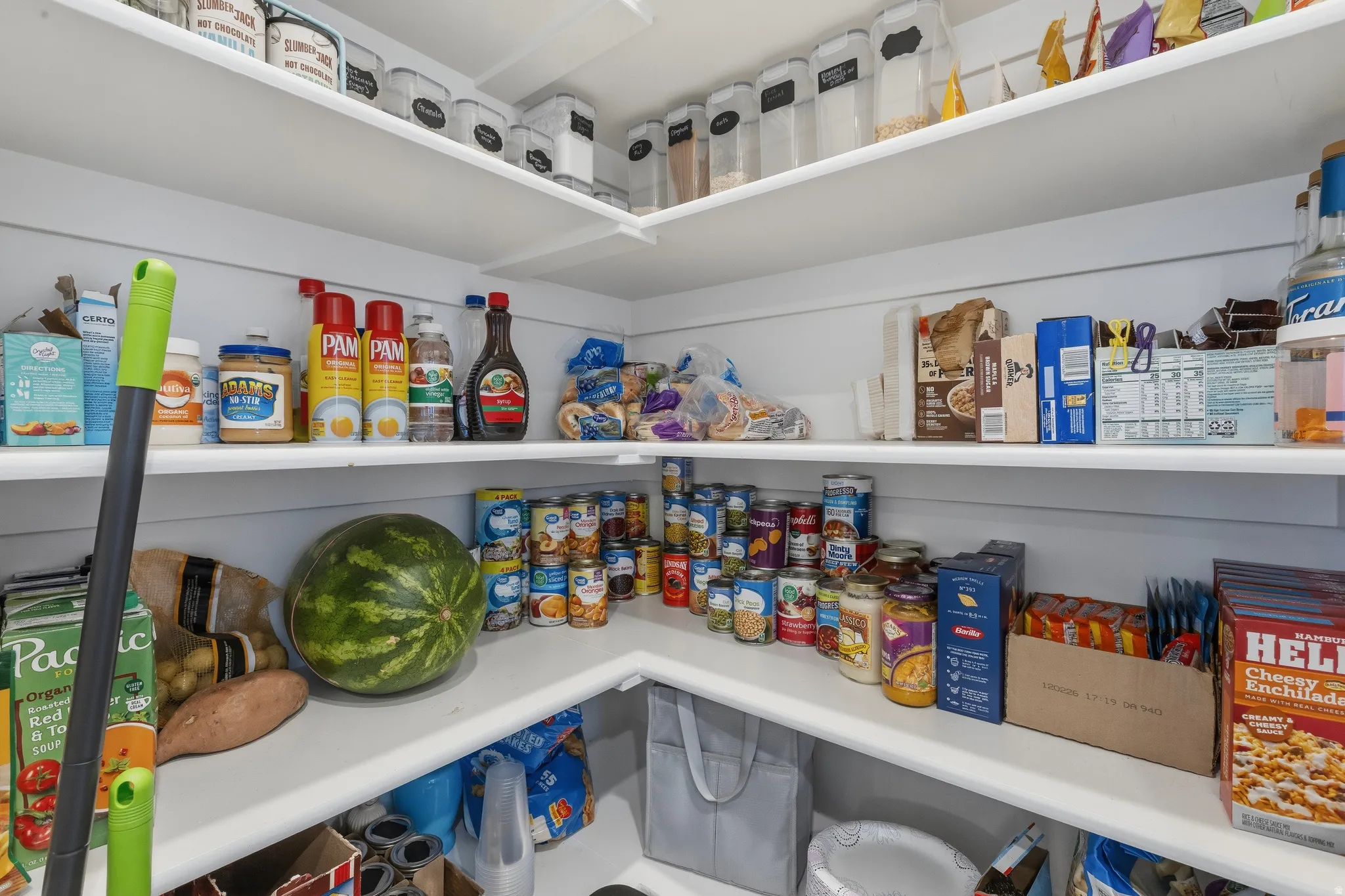 Custom-built pantry with multiple white shelving levels