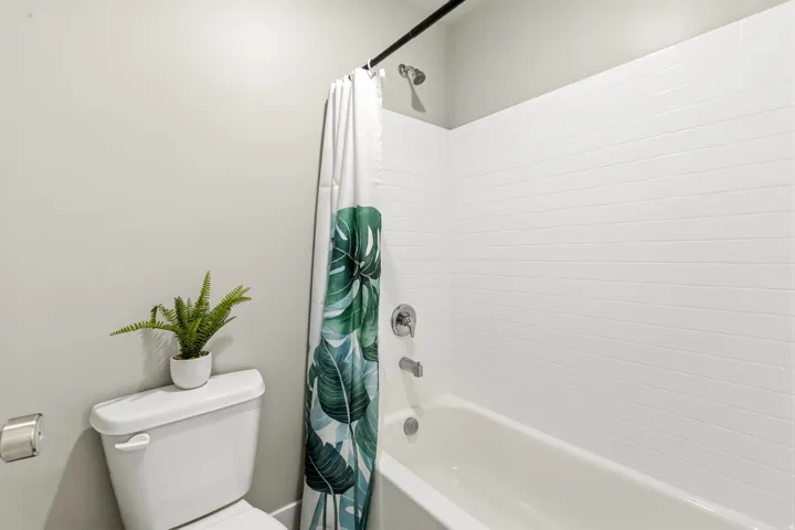 White subway tile shower surround with a built-in tub and chrome fixtures