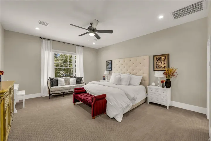 Spacious room featuring neutral-toned walls, recessed lighting, a ceiling fan, a large window with white curtains, and broad white baseboards
