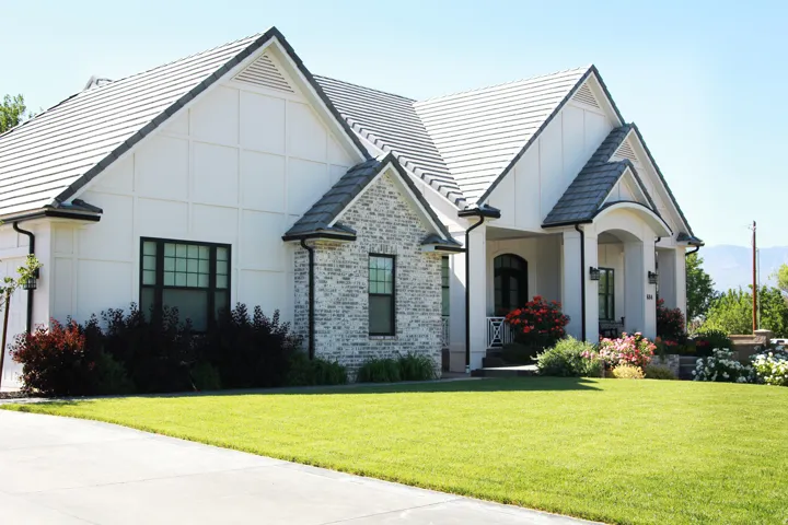 White exterior with board and batten siding and light-colored brick accents