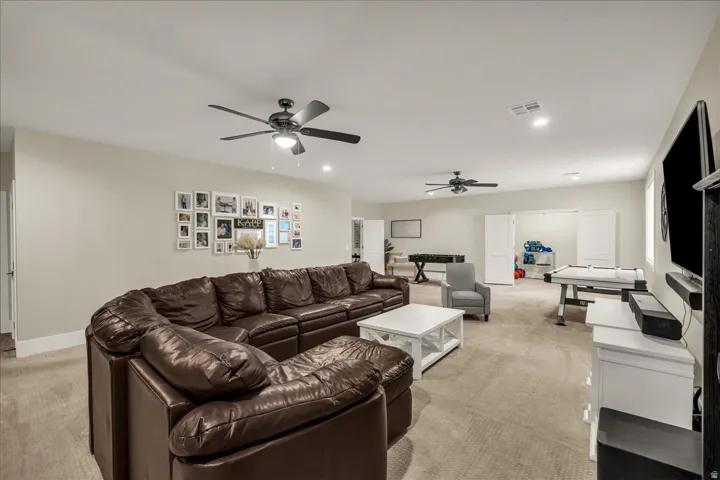 Spacious bonus room featuring neutral carpeting, recessed lighting, and dual ceiling fans