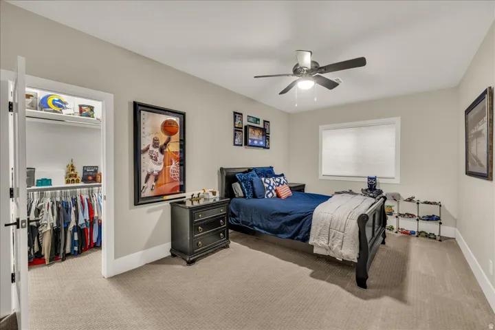 Bedroom with neutral wall color, carpet flooring, a window with blinds, and a ceiling fan