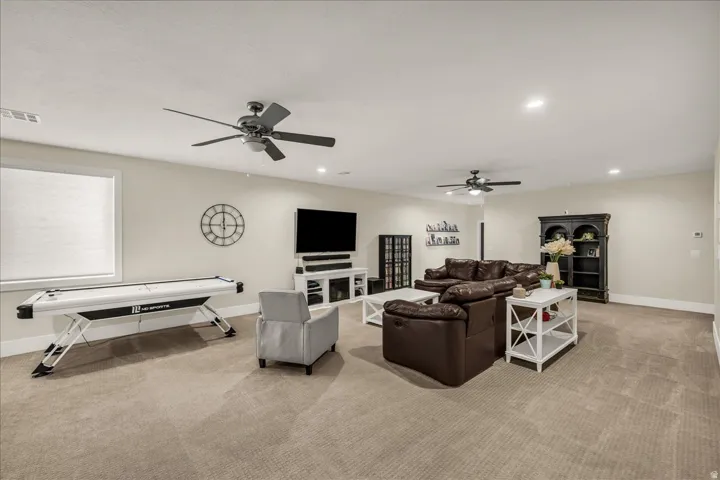 Spacious recreational room featuring recessed lighting and two ceiling fans
