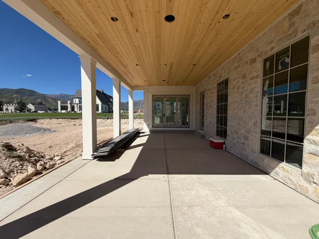 Covered patio with a wood-finish ceiling, recessed lighting, and stone exterior wall