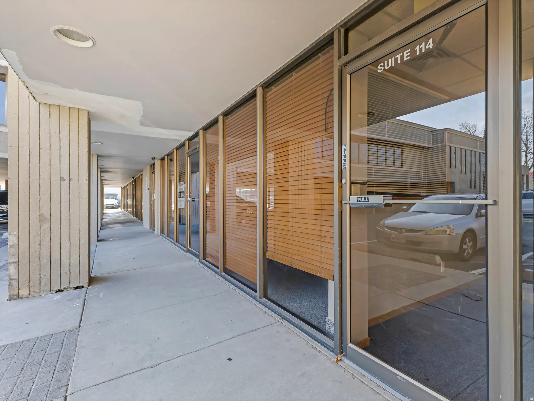 Exterior walkway with recessed lighting, concrete flooring, and vertical paneling