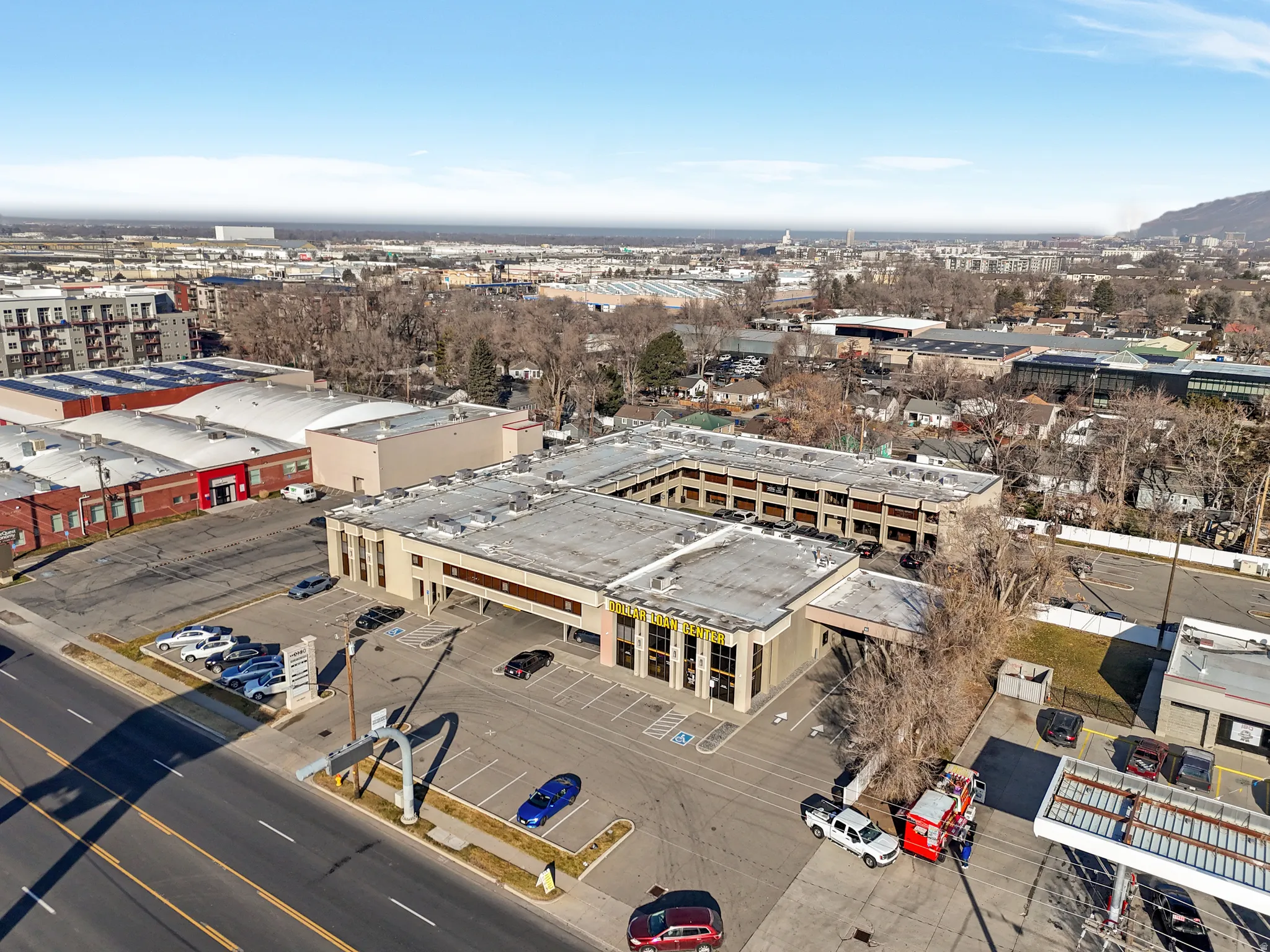 Multi-level commercial building featuring a large surface parking lot, extensive window lines, and multiple entry points