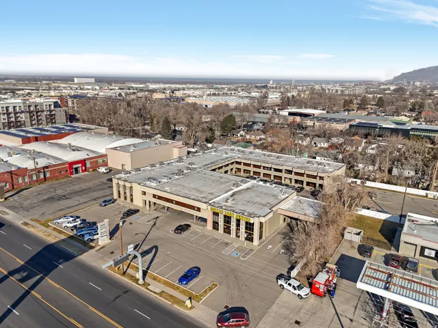 Multi-level commercial building featuring a large surface parking lot, extensive window lines, and multiple entry points