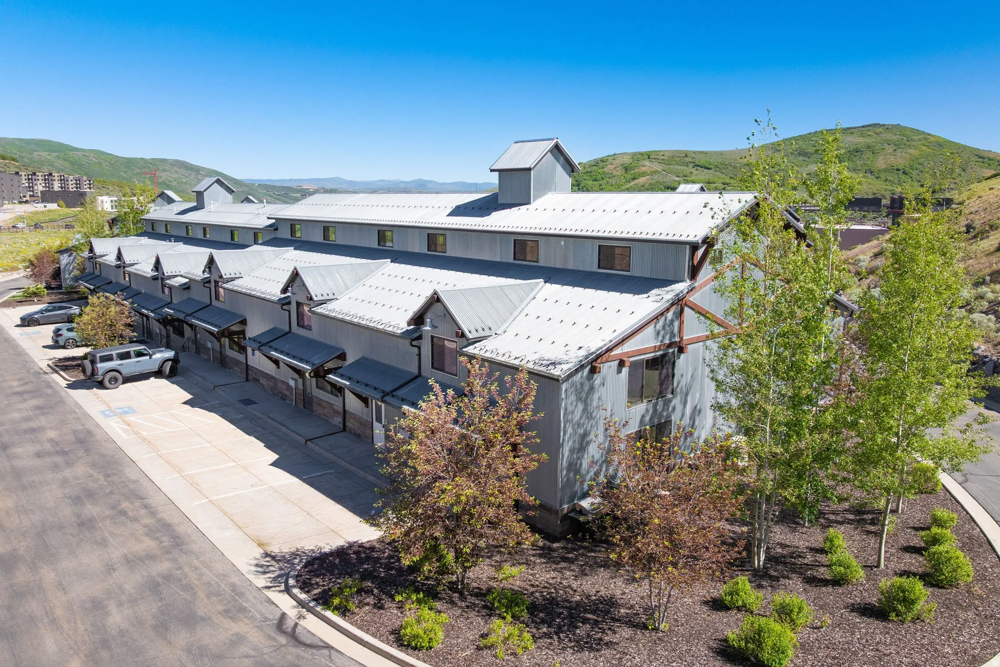 Multi-unit property featuring a contemporary design with gray siding and multiple dormer windows