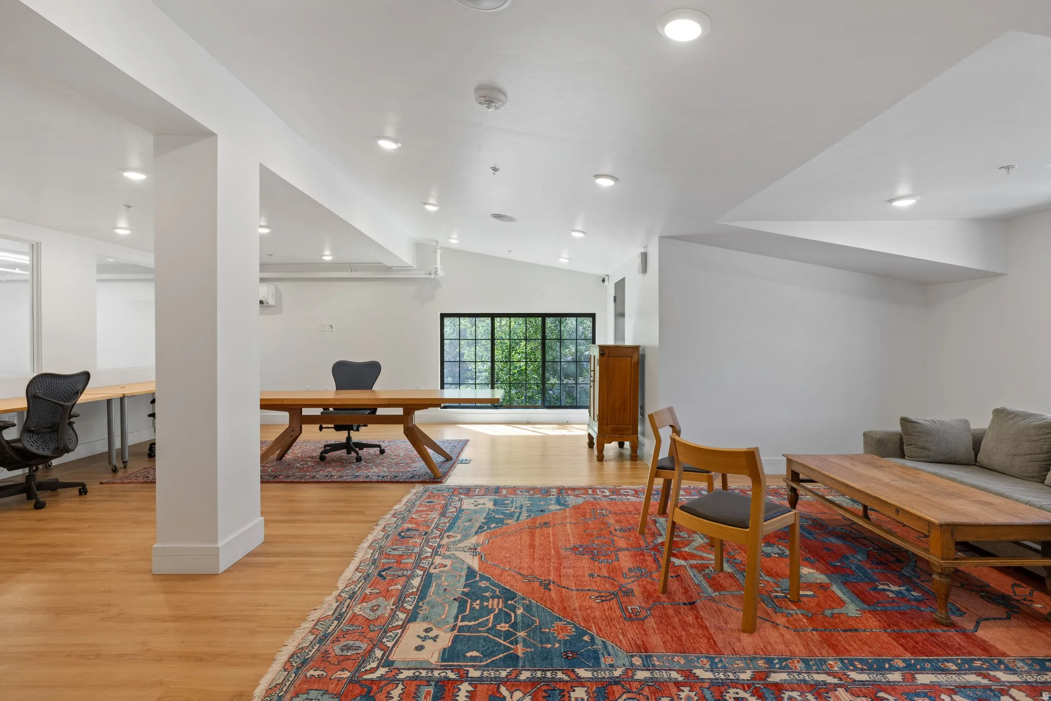 Spacious interior featuring wood-finish flooring, recessed lighting, white walls, and a large multi-pane window