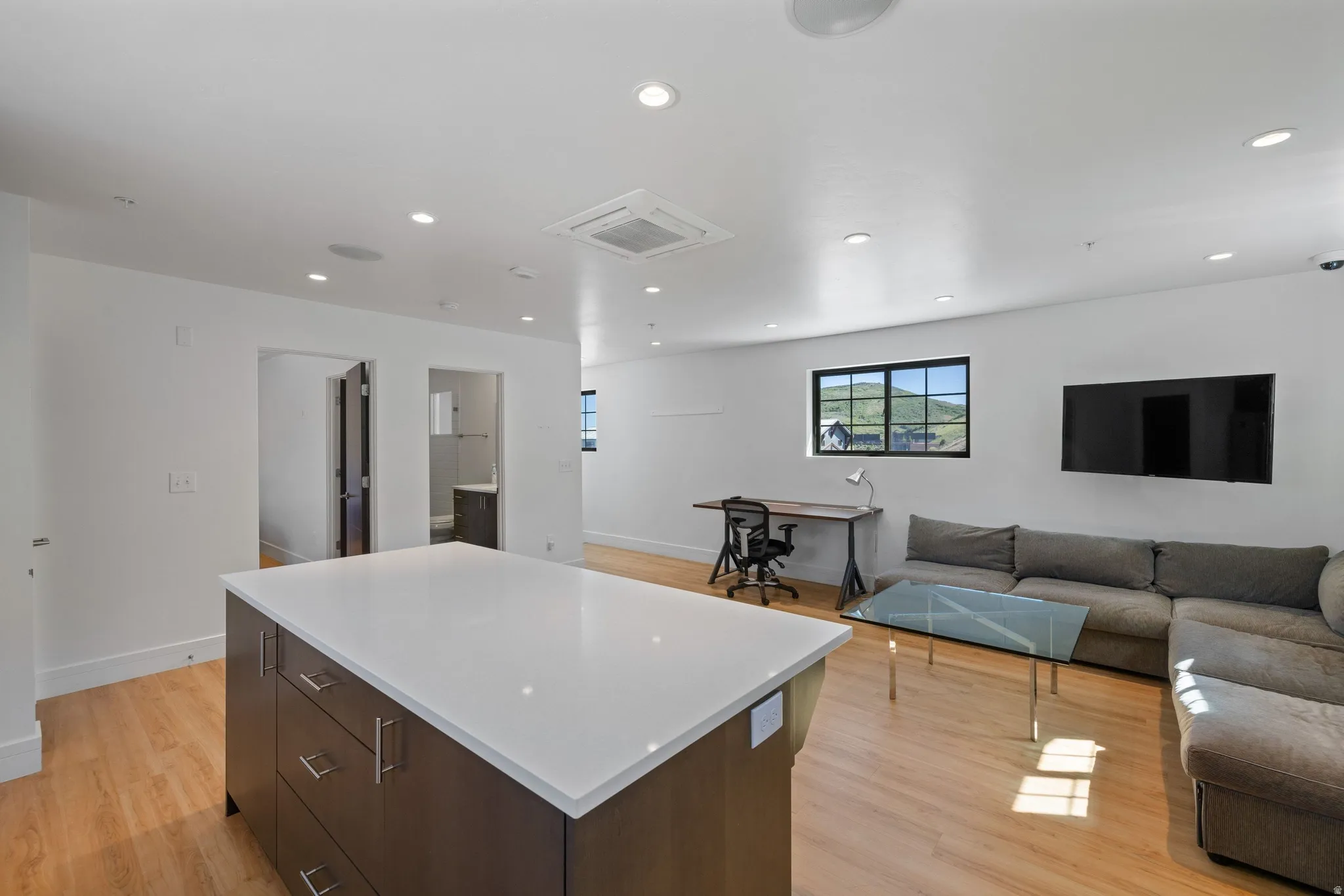Central island with a white countertop and wood-finish cabinetry