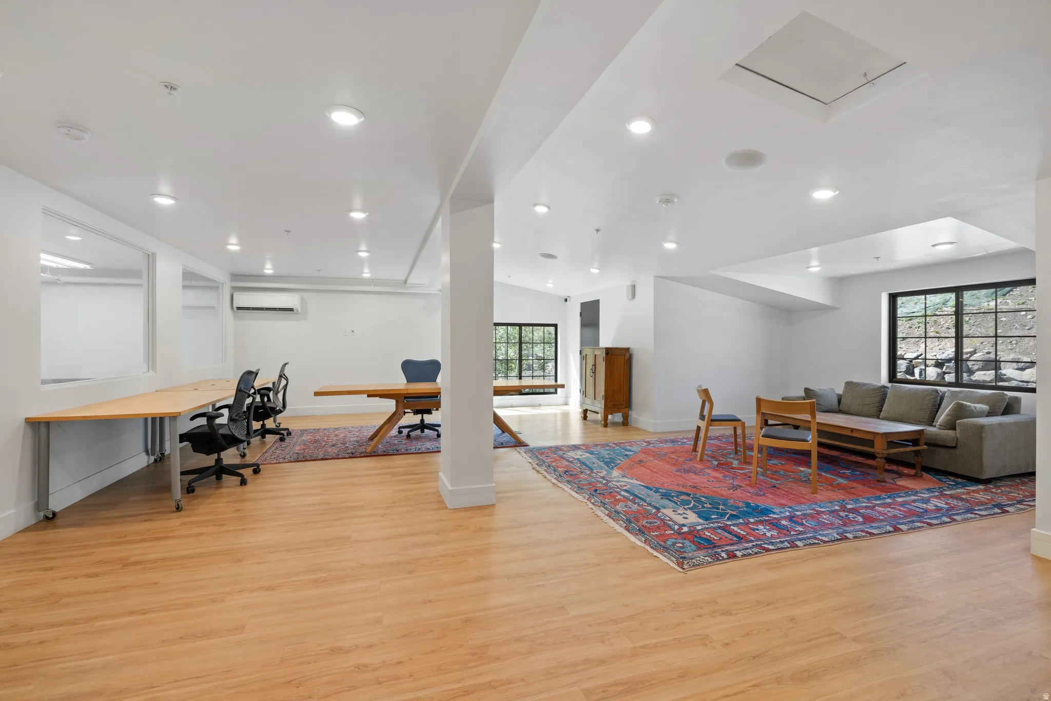 Spacious open-concept room featuring light wood-finish flooring and recessed ceiling lighting
