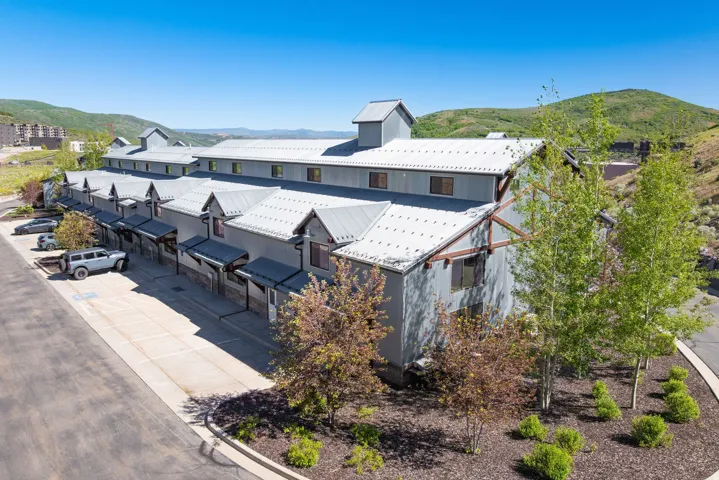 Multi-unit property featuring a contemporary design with gray siding and multiple dormer windows