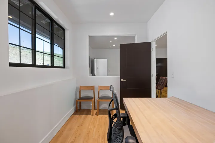 Room featuring wood-finish flooring, recessed lighting, and a large multi-pane window with black framing
