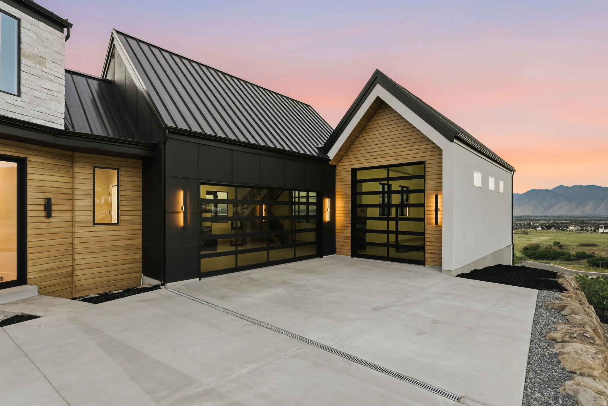 Modern architectural design featuring vertical wood siding, dark metal accents, and a corrugated metal roof
