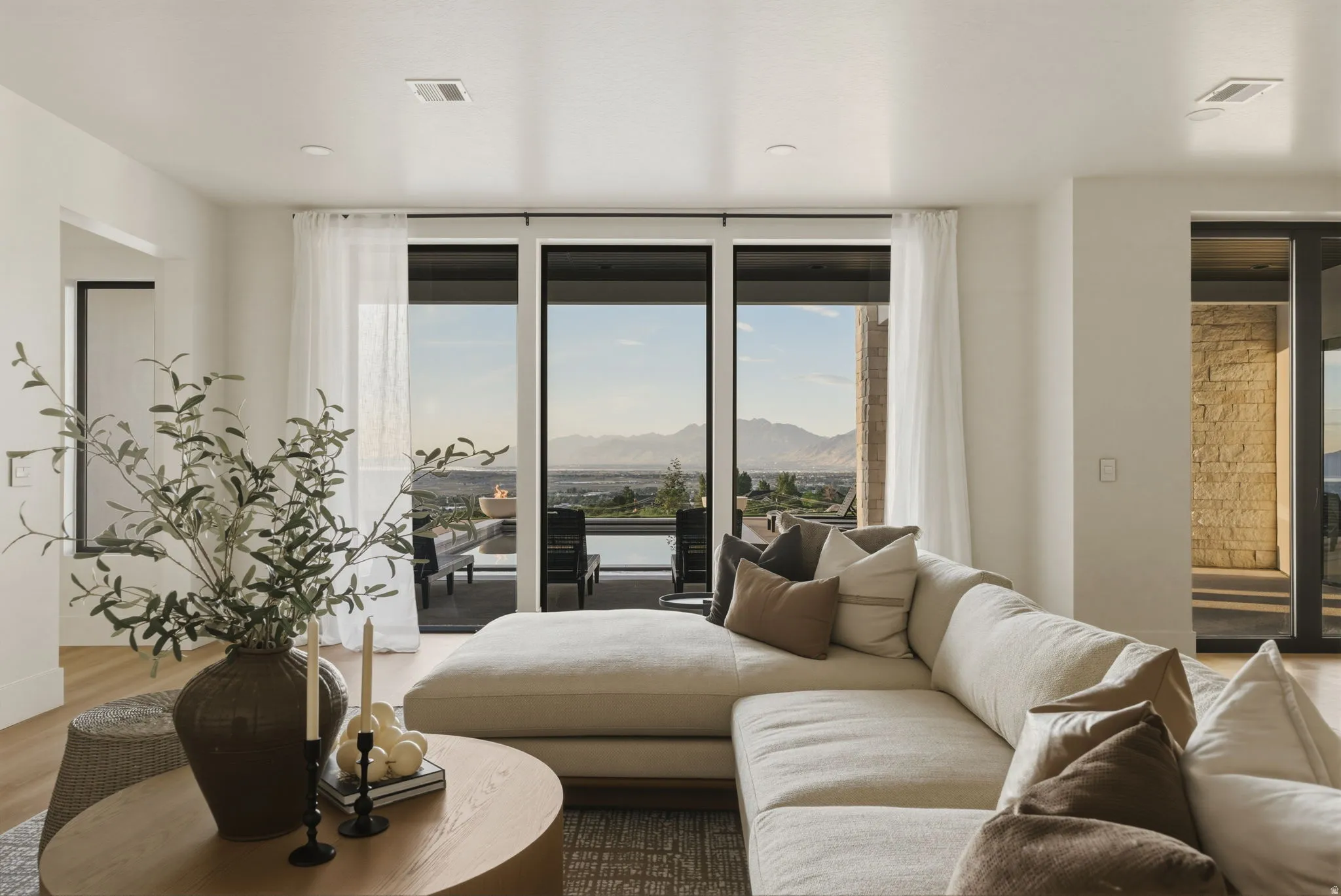 Open-concept living area with wood-finish flooring, recessed lighting, and large sliding glass doors