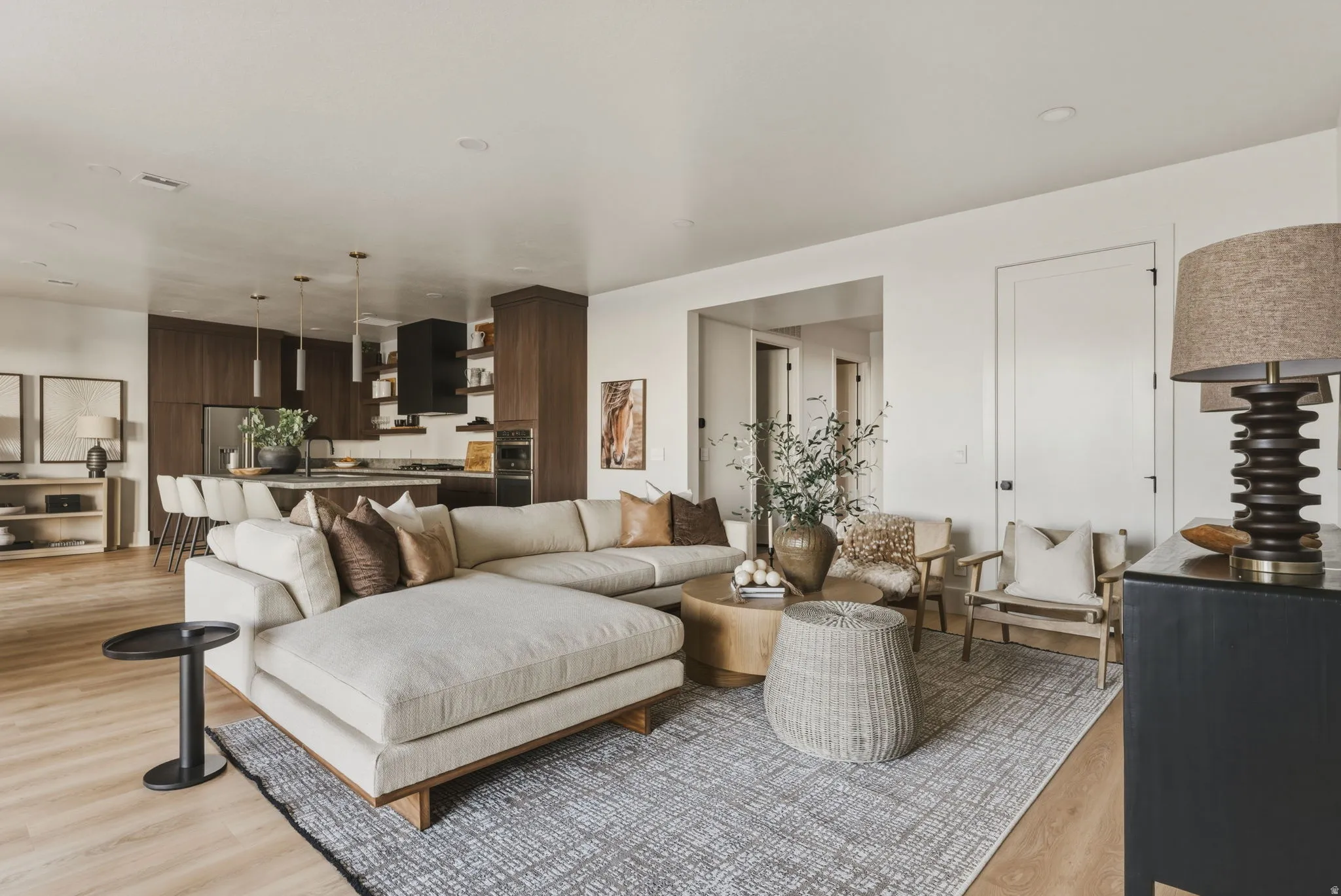 Open-concept living space featuring wood-finish flooring, recessed lighting, and a white interior door