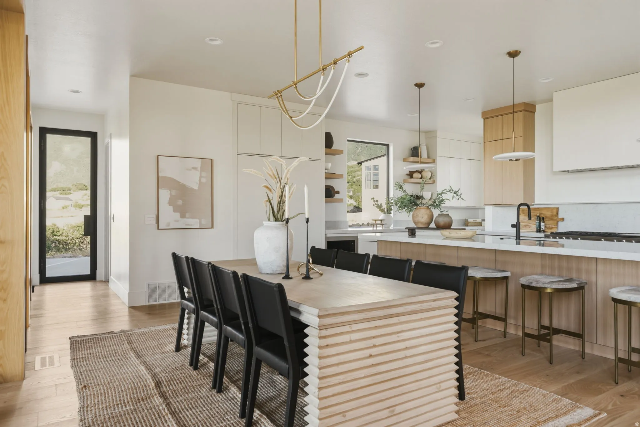Open-concept dining and kitchen area with light wood-finish flooring