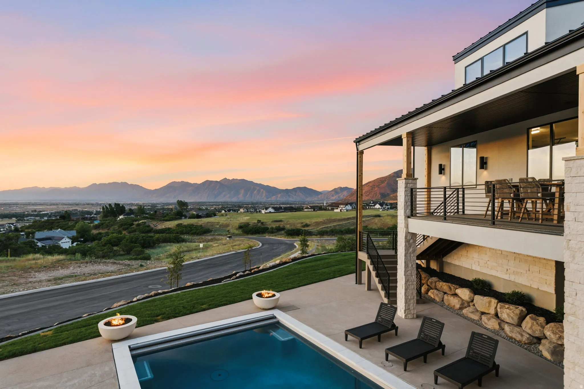 Contemporary exterior featuring a private swimming pool, two fire bowls, and an upper-level balcony with a railing system