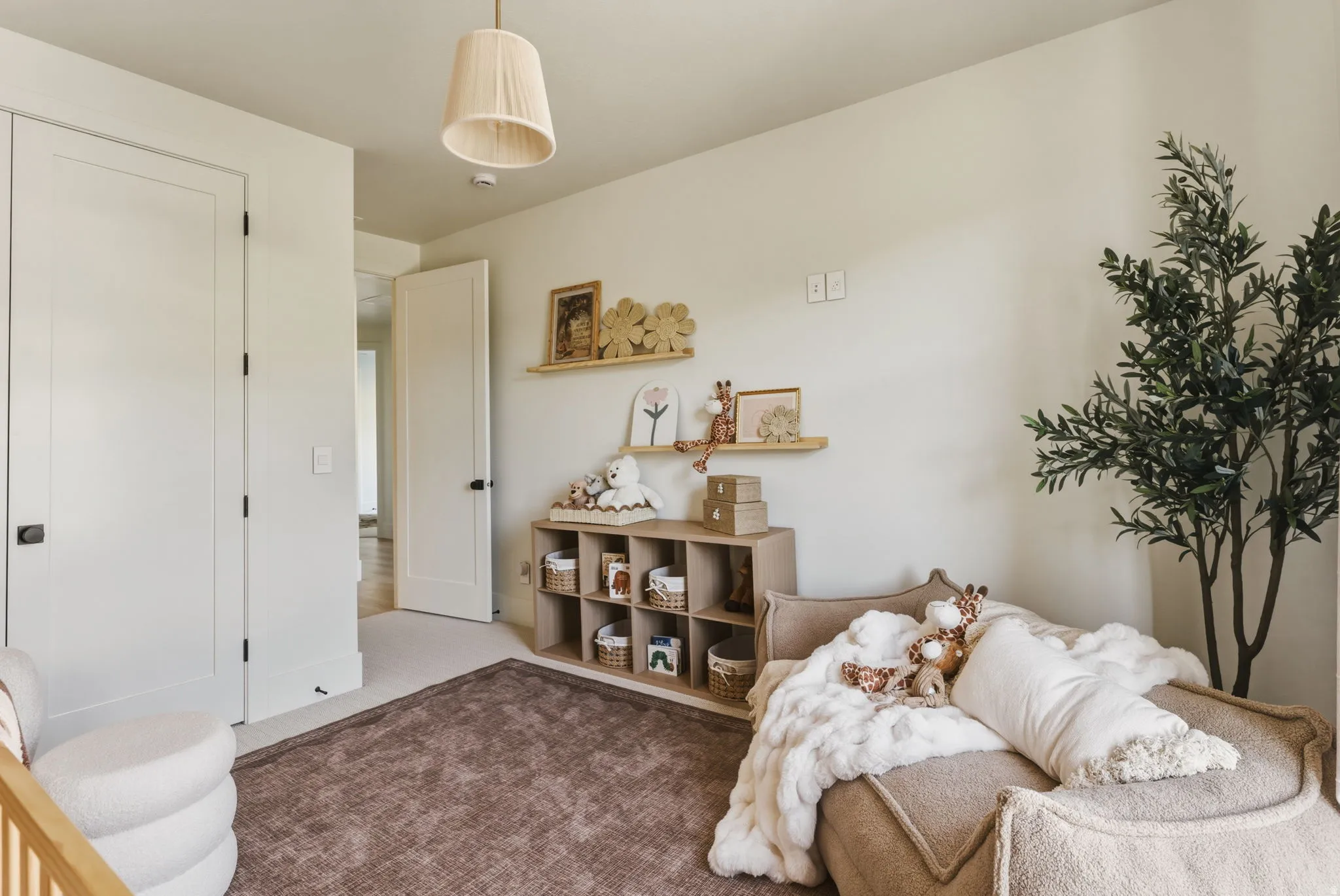 Neutral-toned room with light beige wall paint, two white paneled doors with black hardware, and an overhead pleated fabric pendant light fixture