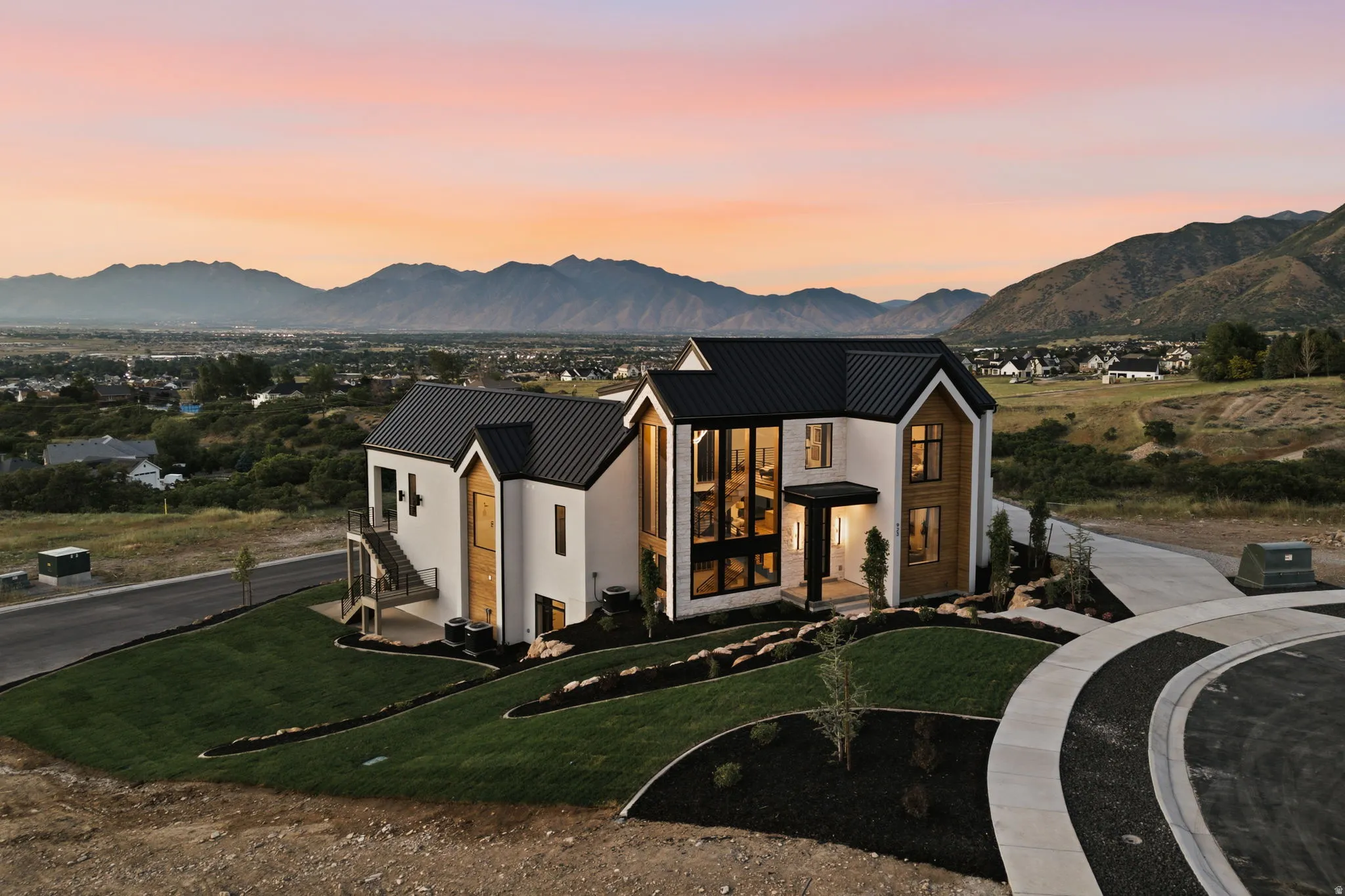 Contemporary architecture featuring a white exterior with wood-finish accents and a black metal roof