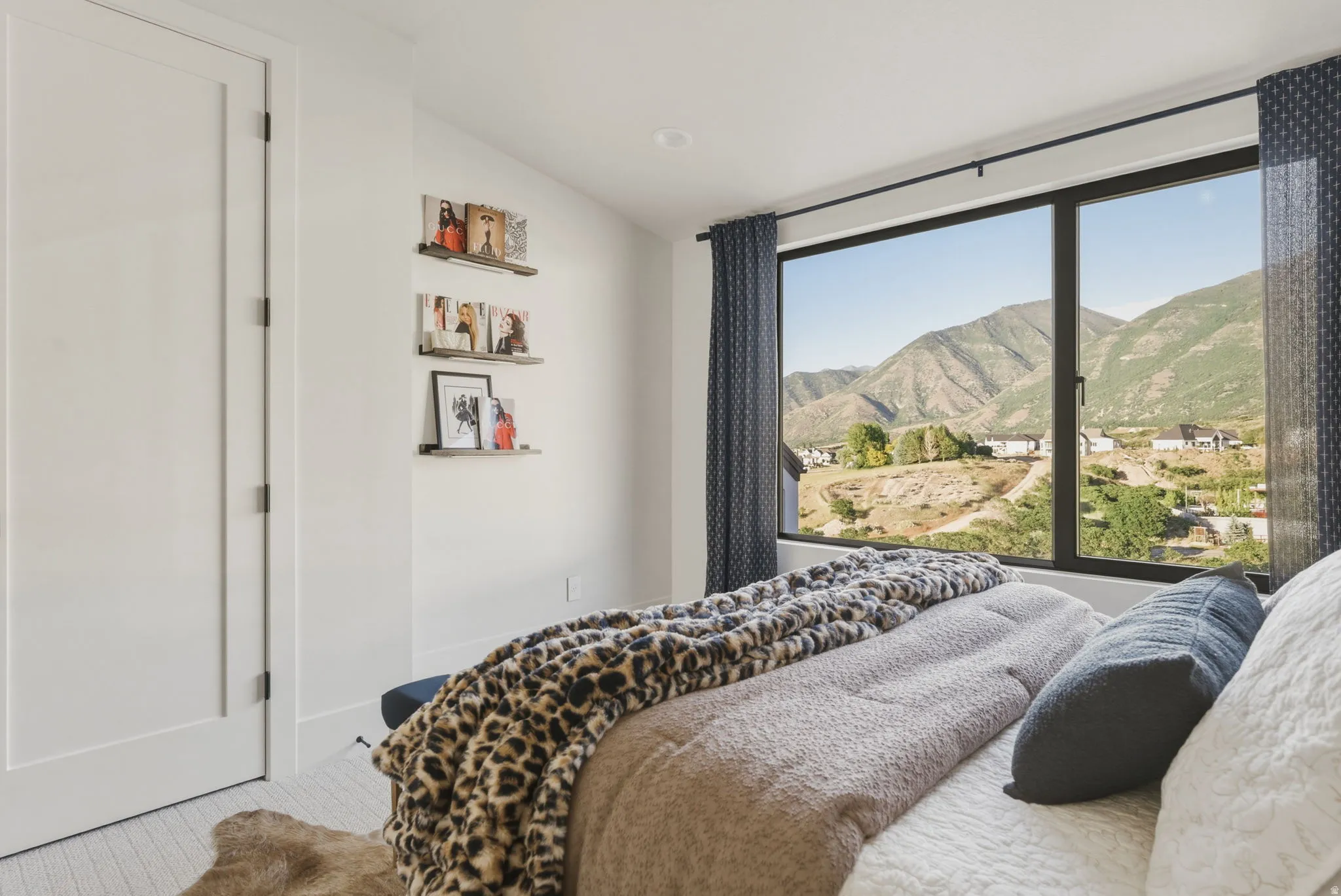 Expansive window offering a mountain landscape, complemented by a white paneled door with dark hardware