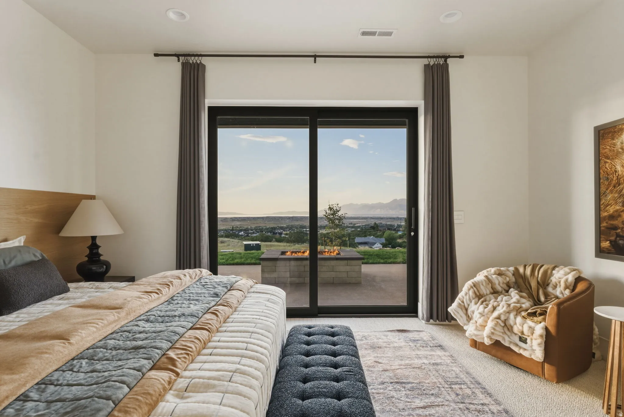 Spacious room featuring a sliding glass door, a private patio, and a built-in fire pit