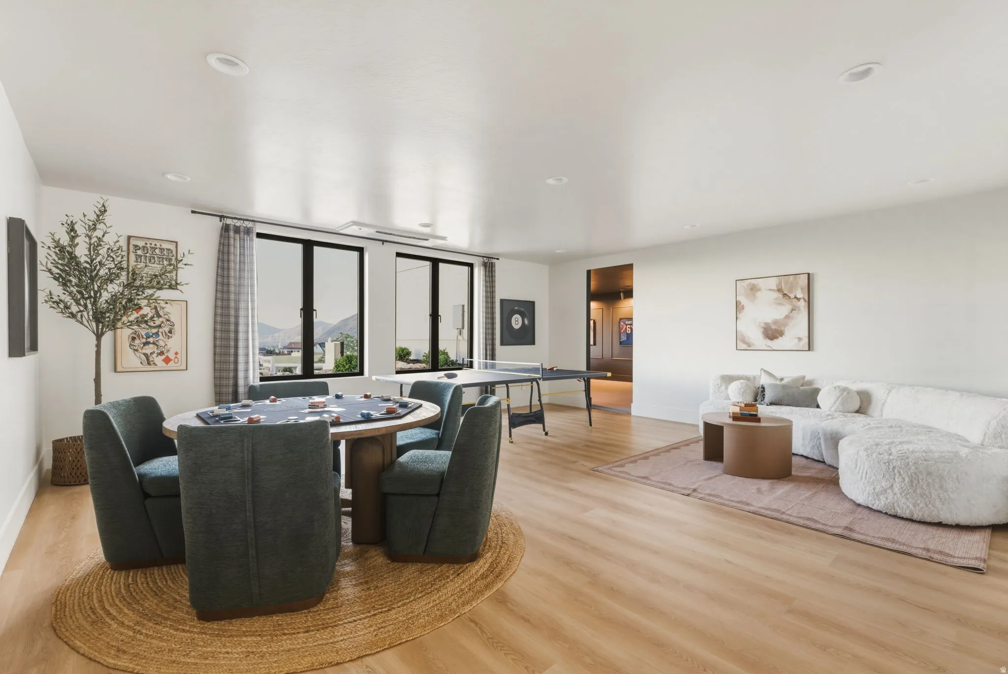 Spacious room featuring light wood-finish flooring, recessed lighting, and white walls
