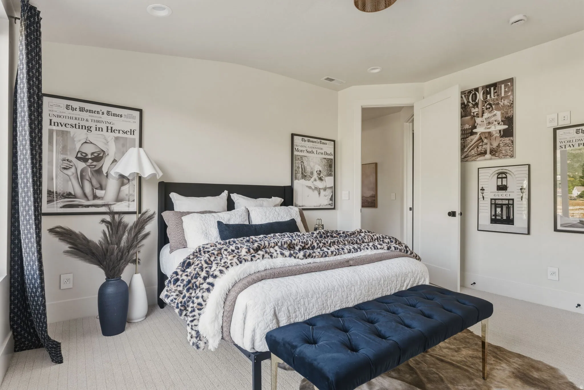 Bright sleeping area featuring recessed lighting, light-toned carpeting, a paneled door with dark hardware, a window with patterned drapes, and white walls