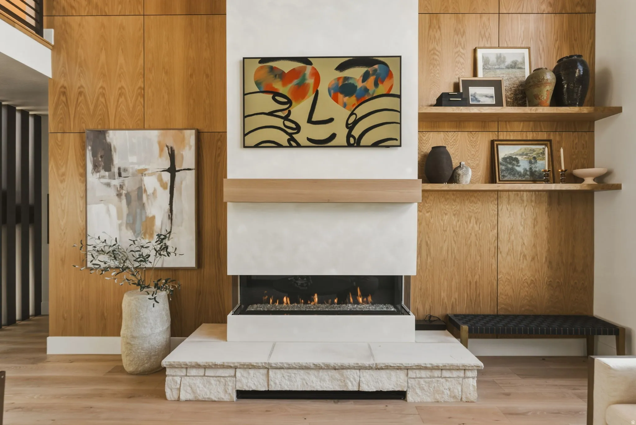 Fireplace featuring a stone hearth, gas insert, and light wood mantel