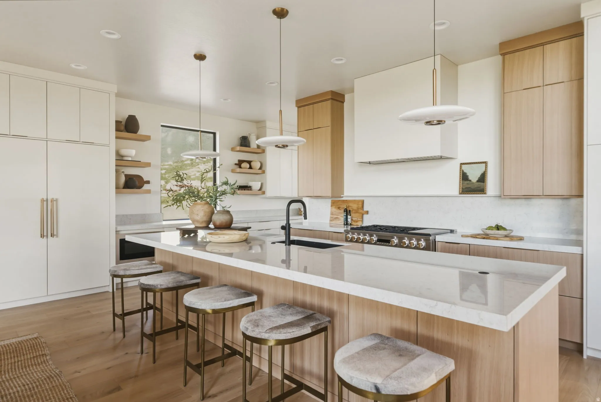 Spacious kitchen featuring an extended island with a light-toned countertop, a built-in range, and a white tile backsplash