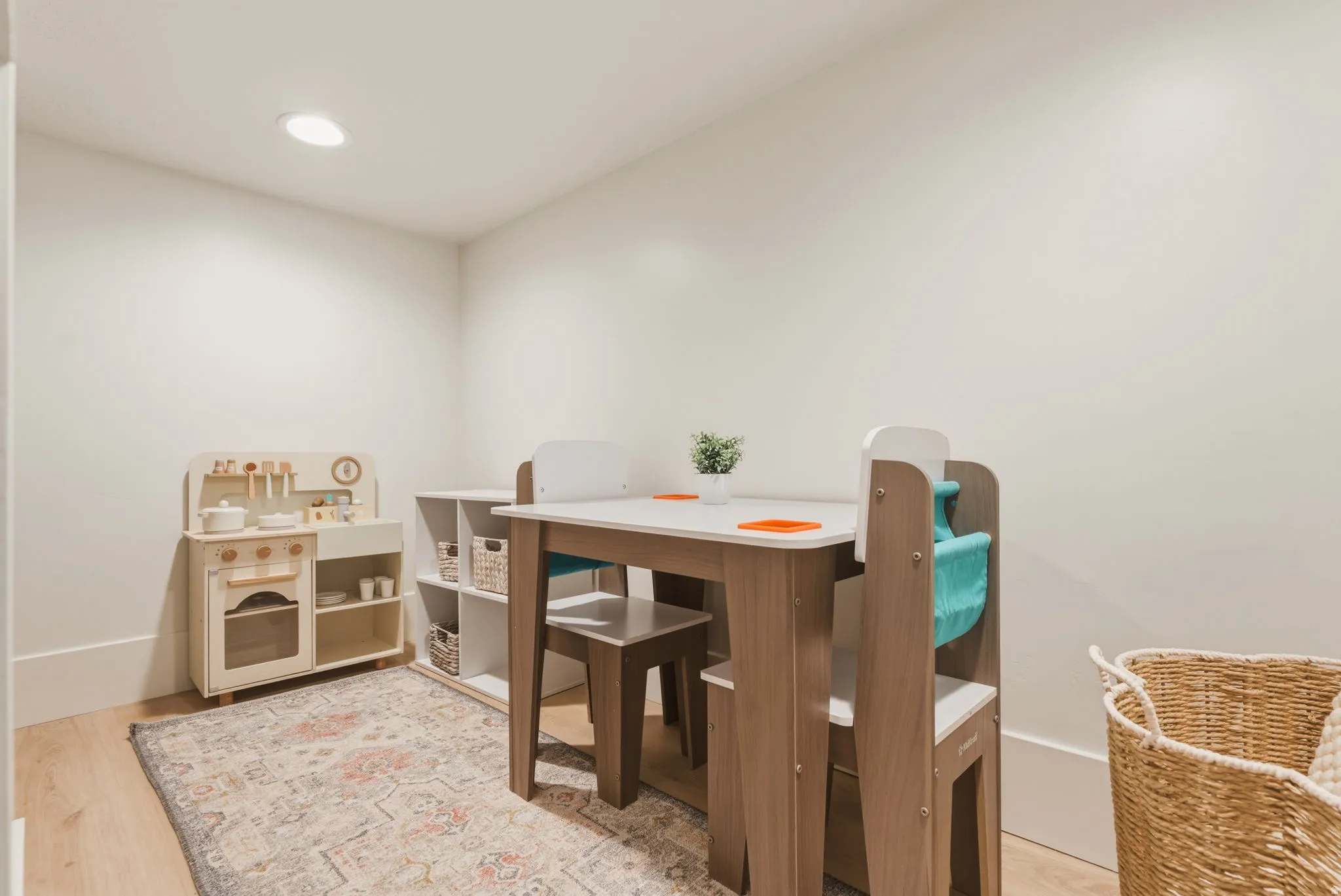 Recessed ceiling lighting illuminates this versatile room, featuring light wood-finish flooring and neutral wall tones