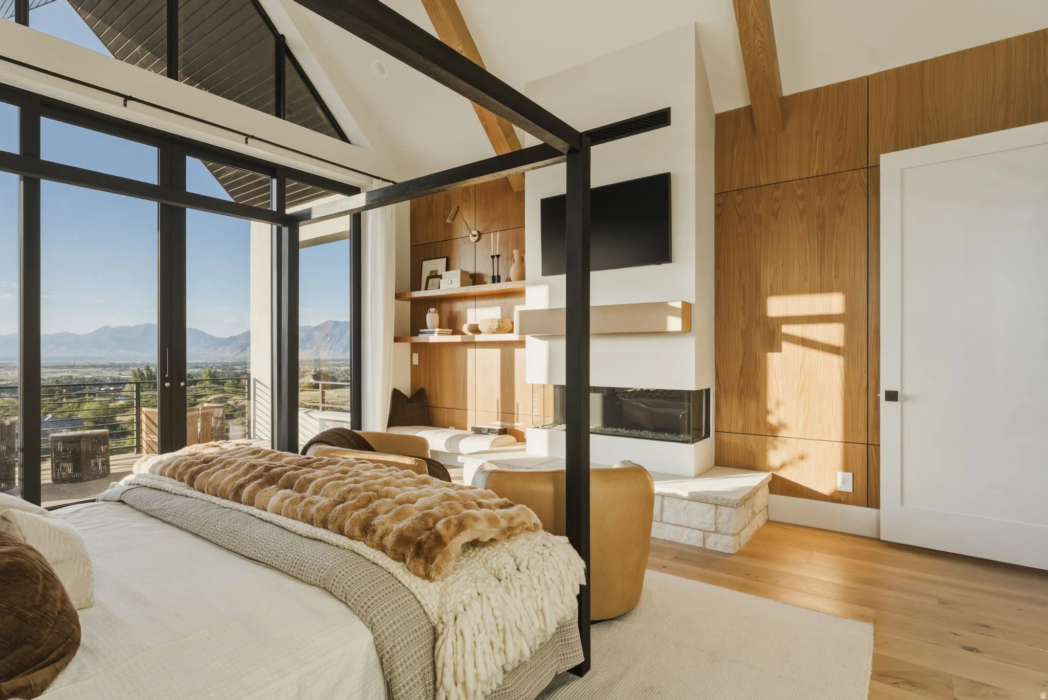 Vaulted ceilings with exposed beams complement expansive windows, offering panoramic outdoor scenery