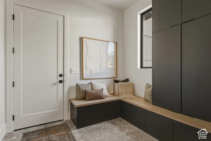 Integrated mudroom storage featuring dark cabinetry, natural wood-finish bench seating, and a large window