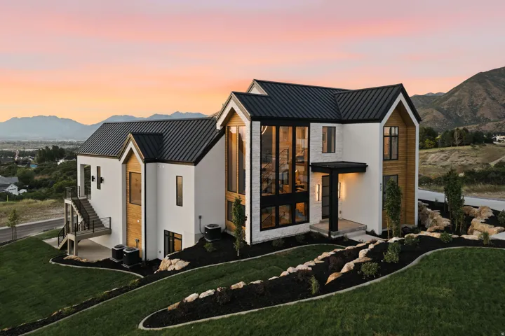 Contemporary exterior architecture featuring a white facade, wood-finish accents, and a black metal roof