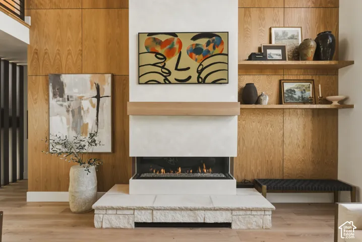 Fireplace featuring a stone hearth, gas insert, and light wood mantel