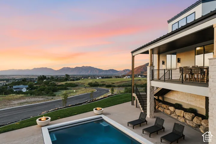 Contemporary exterior featuring a private swimming pool, two fire bowls, and an upper-level balcony with a railing system