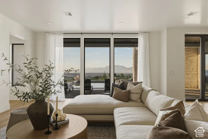 Open-concept living area with wood-finish flooring, recessed lighting, and large sliding glass doors