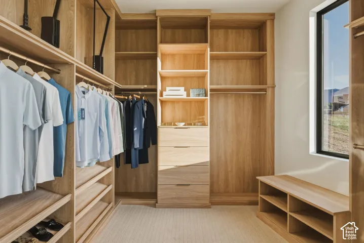 Custom wood-finish closet system featuring integrated shelving, multiple hanging rods, and built-in drawers