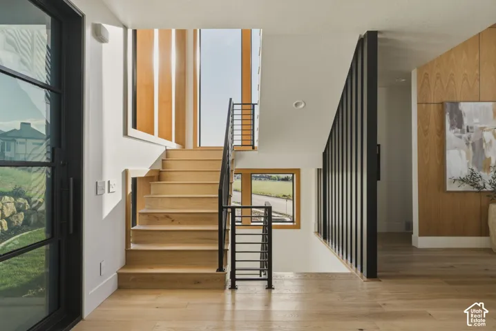 Light wood-finish staircase with black metal railings