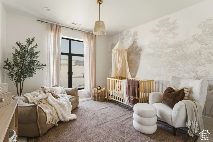 Room featuring a large window with floor-length drapes, a unique patterned accent wall, and recessed ceiling lighting